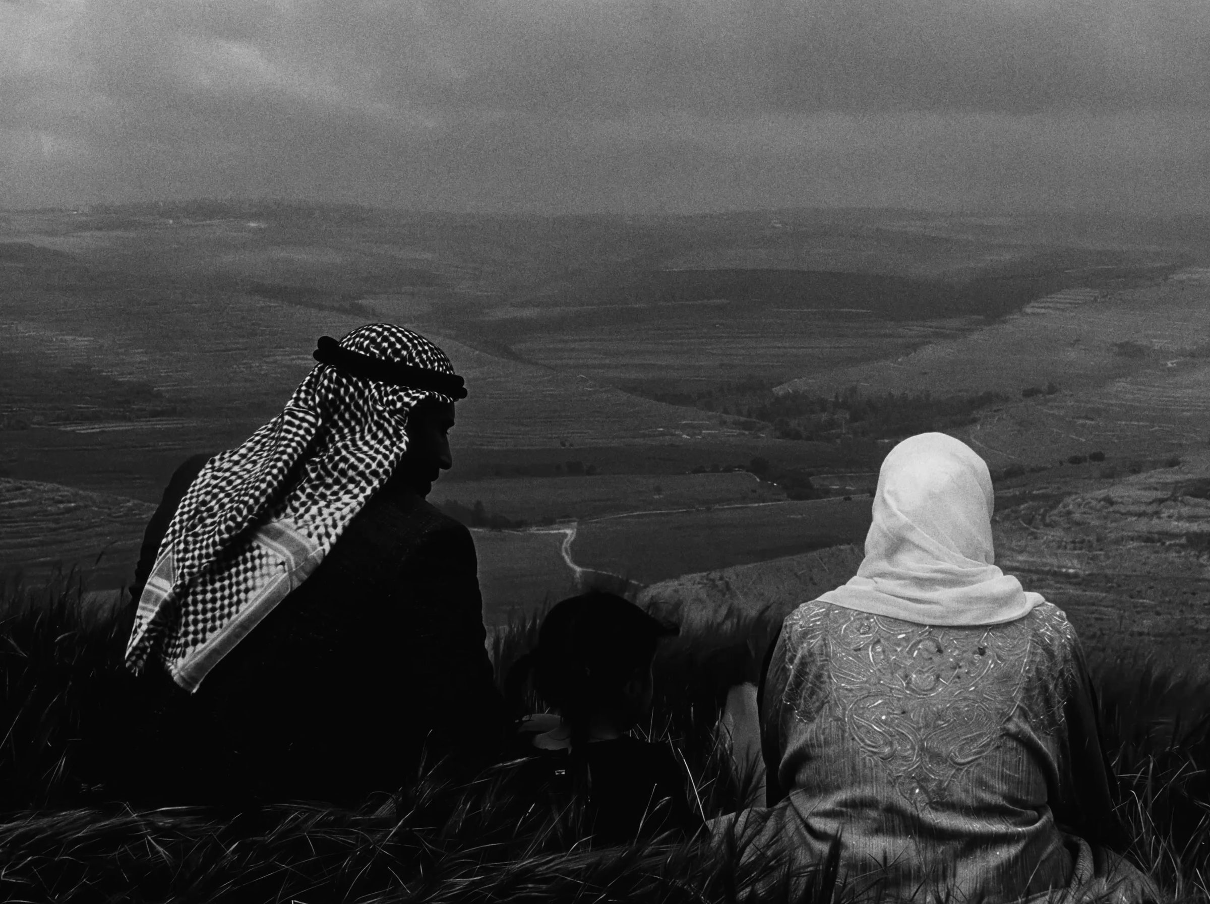 A man and a woman seated, looking out over the valley.